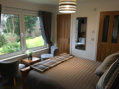 a bedroom with a bed and a large window at Brecbennoch in Oban