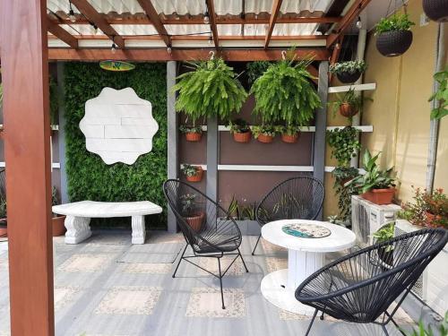 a patio with chairs and a table and plants at Hotel Boutique Malibu Los Sueños in Tigre