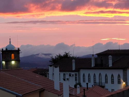 een uitzicht op een gebouw met een klokkentoren bij zonsondergang bij Casa do Visconde 