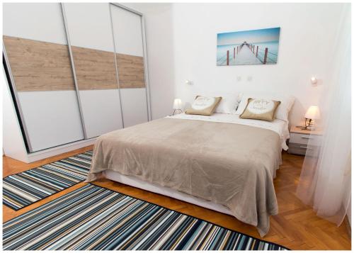 een slaapkamer met een bed en een groot raam bij Large apartment between Split and Trogir in Kaštela