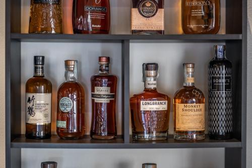 a shelf with several bottles of whiskey on it at Hotel More di Cuna in Monteroni dʼArbia