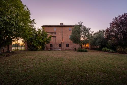 a large brick house with a yard in front of it at Hotel More di Cuna in Monteroni dʼArbia