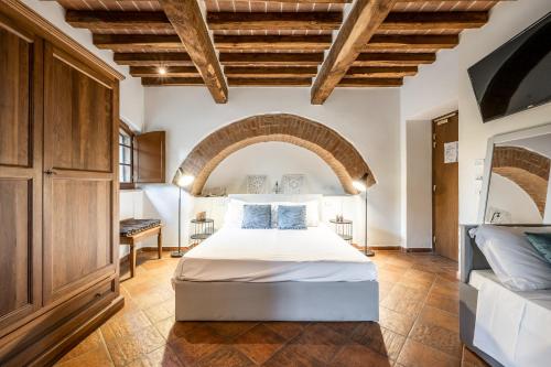 ein Schlafzimmer mit einem Bett in einem Zimmer mit einem Bogen in der Unterkunft Hotel More di Cuna in Monteroni dʼArbia