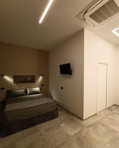una camera da letto con un letto e una TV a parete di La Sartoria dei Sogni a Lucera