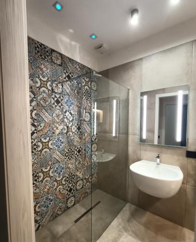 un bagno con lavandino e doccia in vetro di La Sartoria dei Sogni a Lucera