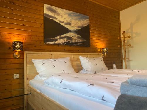 a bedroom with two beds in a wooden wall at Das Fex in Aschau