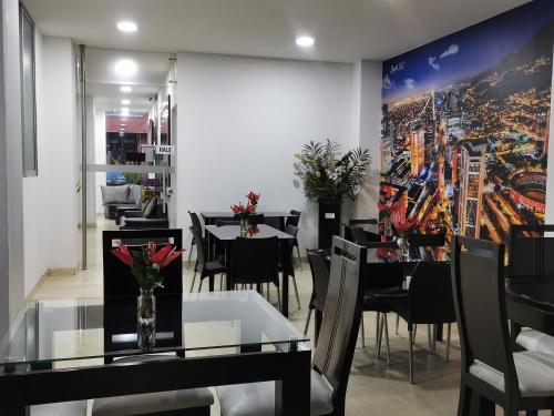 a dining room with tables and chairs and a painting on the wall at Hotel Radel Superior in Bogotá