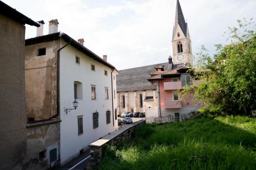 an alley in an old town with a church at La Cles Deluxe Suites in Cles