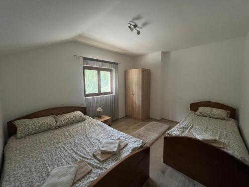 um quarto com 2 camas e uma janela em Mokra Gora Central Apartments em Mokra Gora