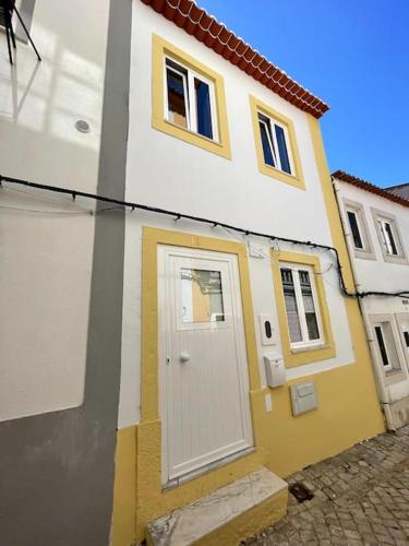 a yellow and white house with a white door at CASA ALCOCHETANA in Alcochete