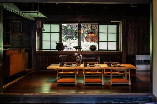 una sala da pranzo con tavolo, sedie e finestra di LiveGRACE House Lake Saiko 西湖古民家 a Yamanashi