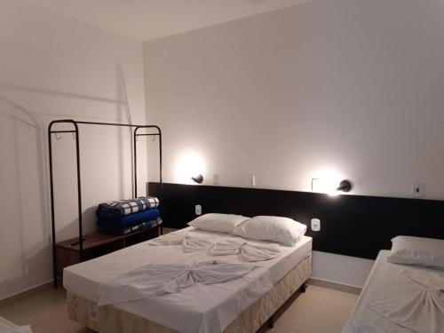 a bedroom with a large bed and two mirrors at Hotel Pousada Santa Maria in Aparecida
