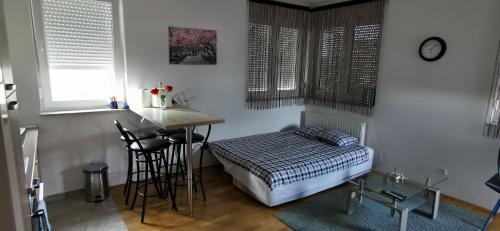a bedroom with a bed and a table and a stool at Apartment Daphnia in Zagreb