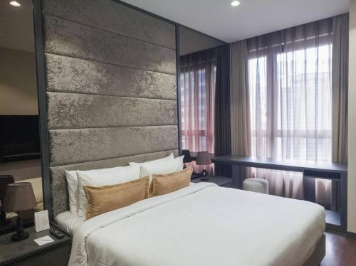 a bedroom with a large bed with a large headboard at WSD Times 8 Luxury Hotels & Residences in Kuala Lumpur