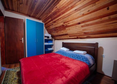 a bedroom with a red bed and a wooden ceiling at Stairway - Vučje in Nikšić