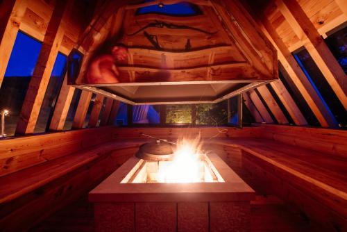 a stove in a wooden cabin with a fire in it at Stairway - Vučje in Nikšić