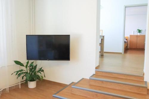 a flat screen tv hanging on a wall in a living room at Pohodlný apartmán s ptačí zahradou in Uherské Hradiště