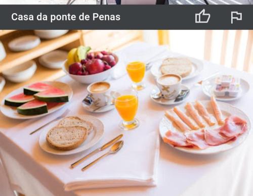 een tafel met borden met voedsel en fruit bij Casa da Ponte de Penas in Melide