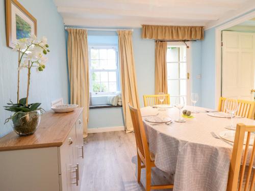 a dining room with a table and a kitchen at Preswylfa in Blaenau-Ffestiniog