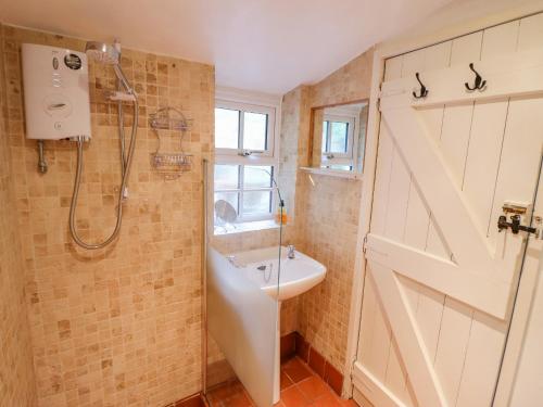 a bathroom with a shower and a sink and a door at Preswylfa in Blaenau-Ffestiniog