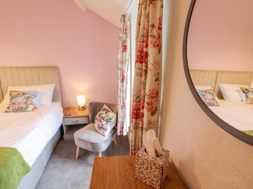 a small room with two beds and a mirror at Preswylfa in Blaenau-Ffestiniog