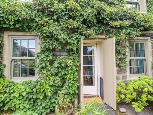 an ivy covered building with a white door and windows at Preswylfa in Blaenau-Ffestiniog