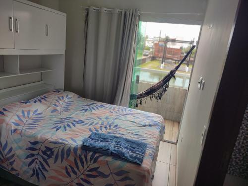 a bedroom with a bed and a balcony with a window at Studio A completo 400m da praia in Porto De Galinhas