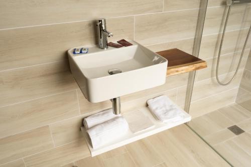 a bathroom with a sink on a wall at Hotel Monte Brasil in Angra do Heroísmo