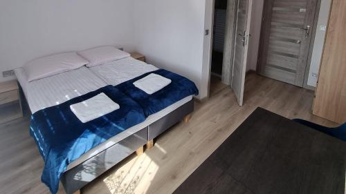 sypialnia z łóżkiem z niebieskim kocem w obiekcie Zacisze na Roztoczu w mieście Horyniec