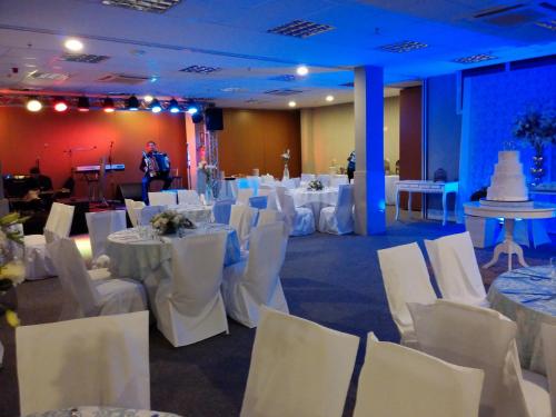 a banquet hall with white tables and white chairs at Days Inn by Wyndham Linhares in Linhares