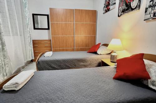 una camera con due letti e una lampada su un tavolo di F2 2 Lovely room, living and bathroom shared , St Julians a San Giuliano