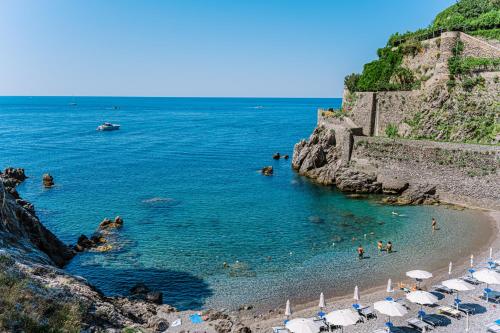a beach with umbrellas and people in the water at Acquachiara Seaside Luxury Villa in Amalfi Coast in Maiori