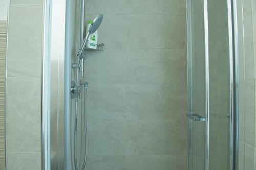 y baño con ducha y puerta de cristal. en La Casa di Gianluca, en Golfo Aranci