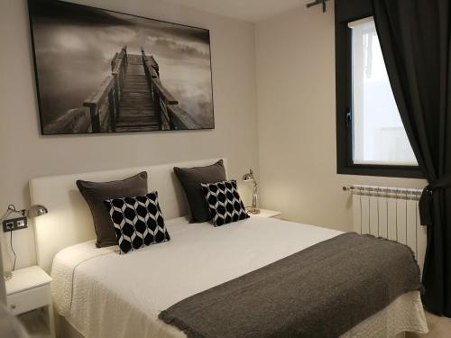 a bedroom with a bed with black and white pillows at Glory Suite Zurriola Beach with AC in San Sebastián