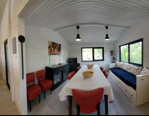 a dining room with a table and red chairs at Pensiunea Casa Dacilor in Podeni
