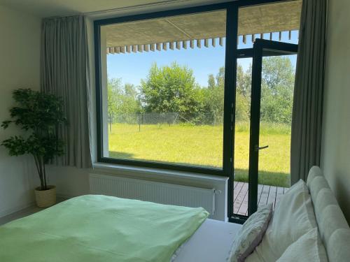 ein Schlafzimmer mit einem Bett und einem großen Fenster in der Unterkunft Apartmán Darsinka in Stachy