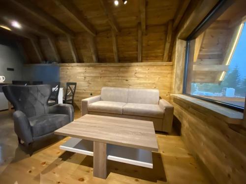 a living room with a couch and a table and a chair at DANDELION HOUSE in Žabljak