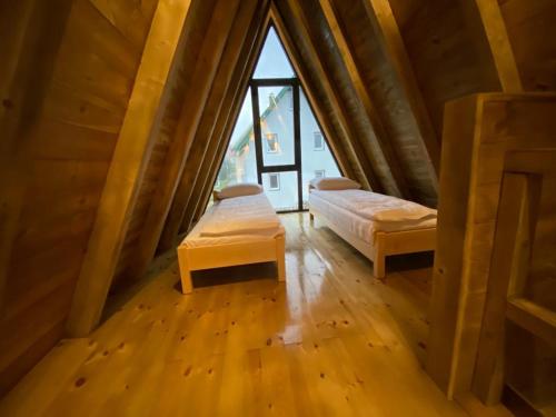 a attic room with two beds and a window at DANDELION HOUSE in Žabljak