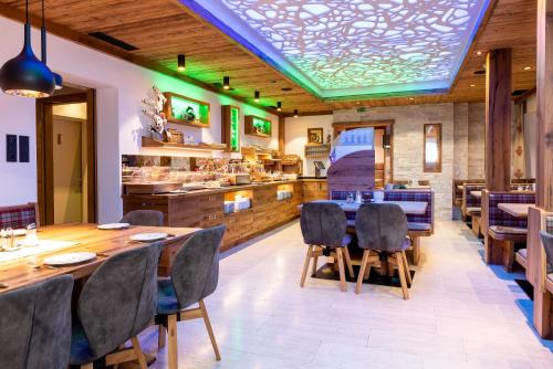 a restaurant with a table and chairs and a bar at Hotel Garni Siegmundshof - inclusive Joker Card im Sommer in Saalbach Hinterglemm