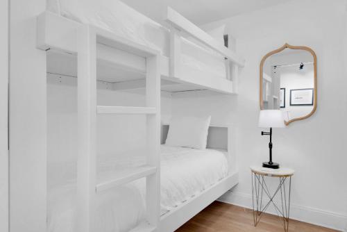 a white bedroom with a bed and a mirror at Laketown Wharf 1714 in Panama City Beach