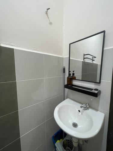 een badkamer met een wastafel en een spiegel bij HOMESTAY BANDAR KANGAR (NS FAMILY HOMESTAY) in Kangar