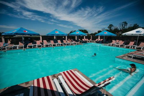 a swimming pool with chairs and blue and white umbrellas at Chalet in Shypyntsi