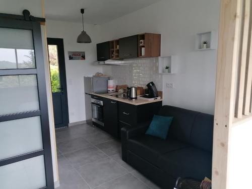 sala de estar con sofá y cocina en Entre Perigueux et Bergerac en Vergt