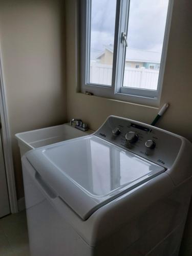 a white sink in a bathroom with a window at Ocean Pointe, Lucea, Hanova, Jamaica in Lucea