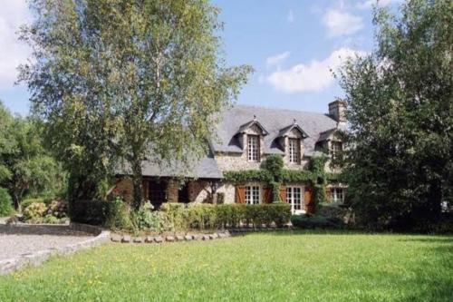 una casa grande con un césped verde delante de ella en Gîte La Maison de Gouville, avec piscine et SPA, proche mer, en Gouville-sur-Mer