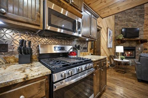 a kitchen with a stove and a living room at Misty Mountain in Stephens Gap