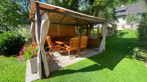 a gazebo with a table and chairs in a yard at Gästehaus Rader in Weissbriach