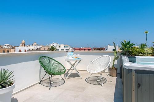 a patio with two chairs and a table on a roof at Belvedere Apartment & Pool - Housea in Polignano a Mare