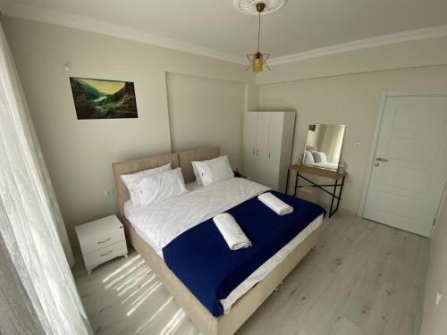 a bedroom with a bed with a blue and white blanket at Misho Apart in Trabzon