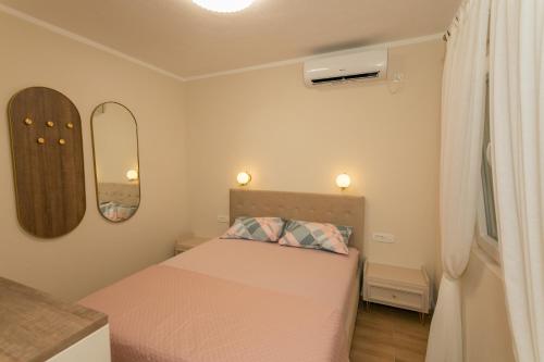 a small bedroom with a bed and two mirrors at Country Homes Dujeva in Rijeka Crnojevića